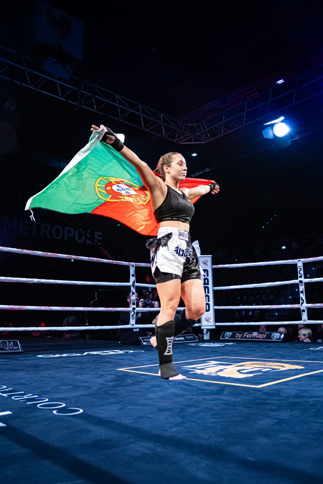 Combattante brandissant le drapeau portugais sur le ring